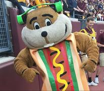 Goldy Gopher in a hotdog suit and wearing headphones.