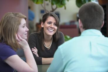Smiling female professor talking to two students